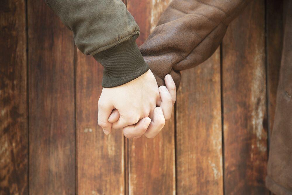 crop men holding hands with love