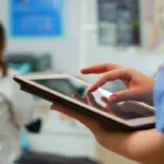 103073553 enfermeira segura tablet enquanto medico atende paciente atras inteligencia artificial
