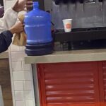 Homem leva galão de 20 litros para encher de refrigerante refil em São Paulo