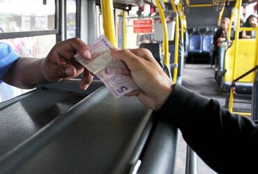 passageiro paga passagem em onibus urbano
