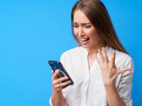 retrato de uma jovem mulher com raiva usando o telefone irritada enviando mensagens de texto com alguem com fundo azul 93675 114208