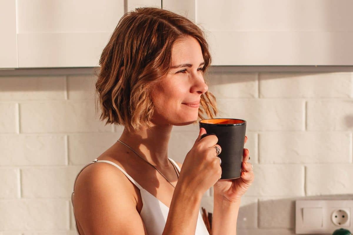 Canva | Mulher tomando café, qual o signo mais feliz da semana