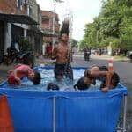 Rio de Janeiro (RJ), 16/11/2023 - Moradores do Complexo da Maré se refrescam com chuveiros e piscinas improvisadas nas ruas da comunidade. A sensação térmica na cidade do Rio de Janeiro voltou a superar os 50 graus Celsius (°C), com a onda de calor que atinge boa parte do Brasil. Foto: Tânia Rêgo/Agência Brasil