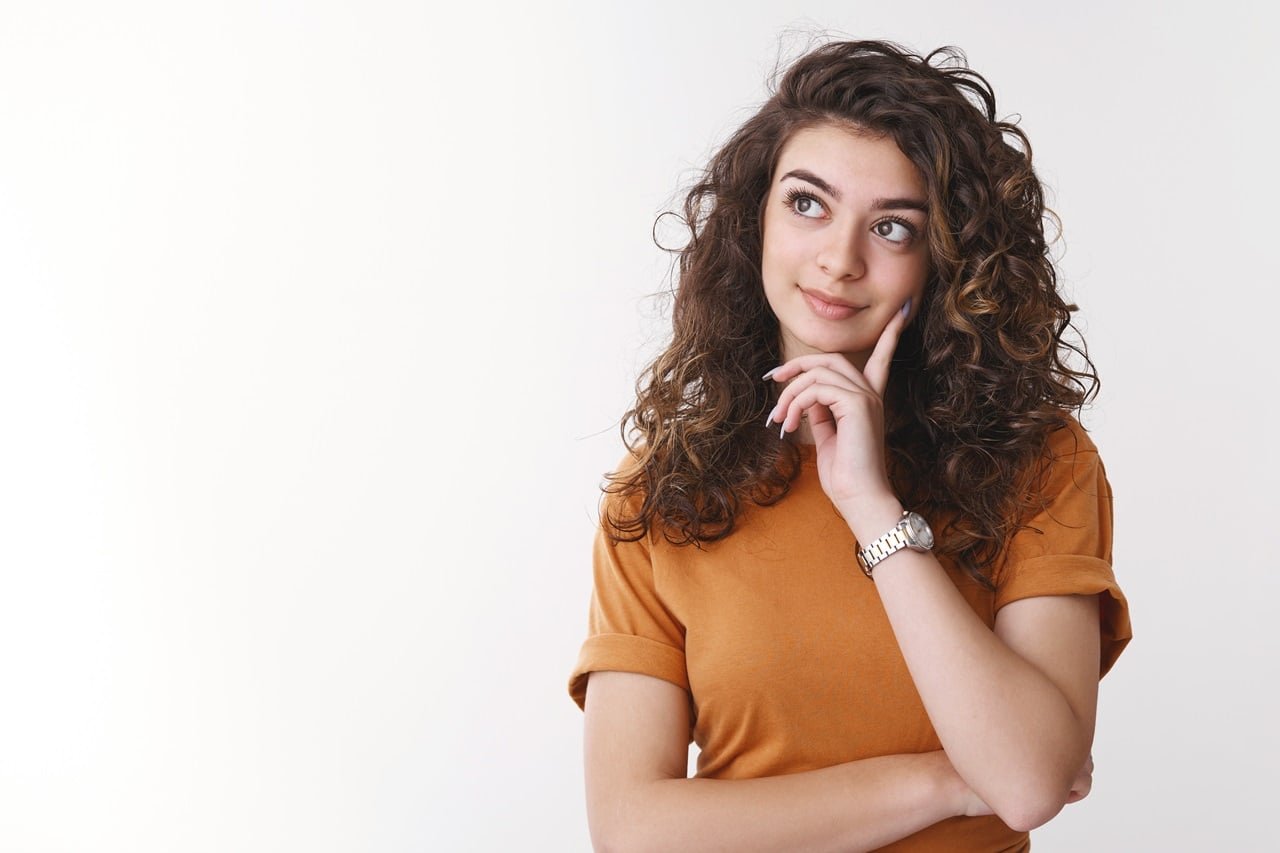 garota decidindo qual produto e melhor procurar pensativa toque no queixo pensando sorrindo fazendo compras sozinha fazendo escolhas considerando propostas