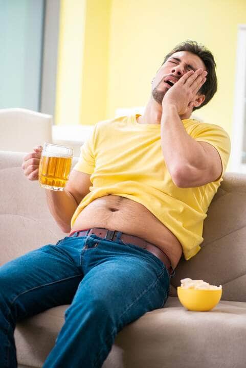 Homem segurando um copo de cerveja em casa - Fotos do Canva