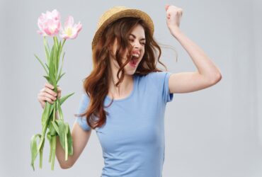 Mulher jovem feliz segurando flores - Fotos do Canva
