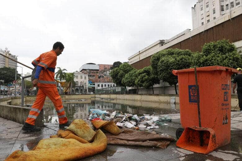Garis recolhem lixo no sítio arqueológico do Cais do Valongo, na região portuária, alagado depois das chuvas. Por: Tânia Rêgo/Agência Brasil