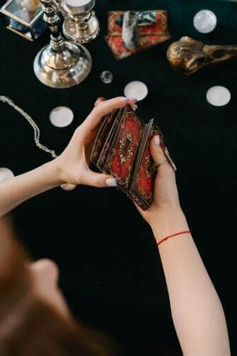 Horóscopo para 10 de maio em cartas de Tarô: Áries - obstáculos, Leões - estresse 4 Cartomante anônima jogando cartas de tarô na mesa - Fotos do Canva