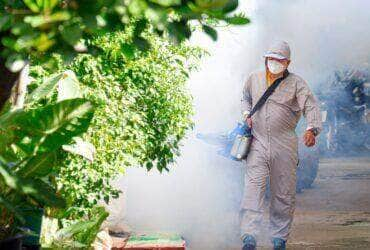 Dengue - Trabalhador de saúde ao ar livre usando máquina de nebulização pulverizando produtos químicos para eliminar mosquitos e prevenir a dengue na área de favela - Fotos do Canva