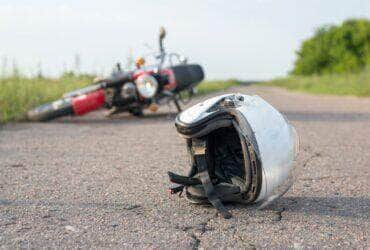 Foto do capacete e da motocicleta na estrada, o conceito de acidentes rodoviários - Fotos do Canva