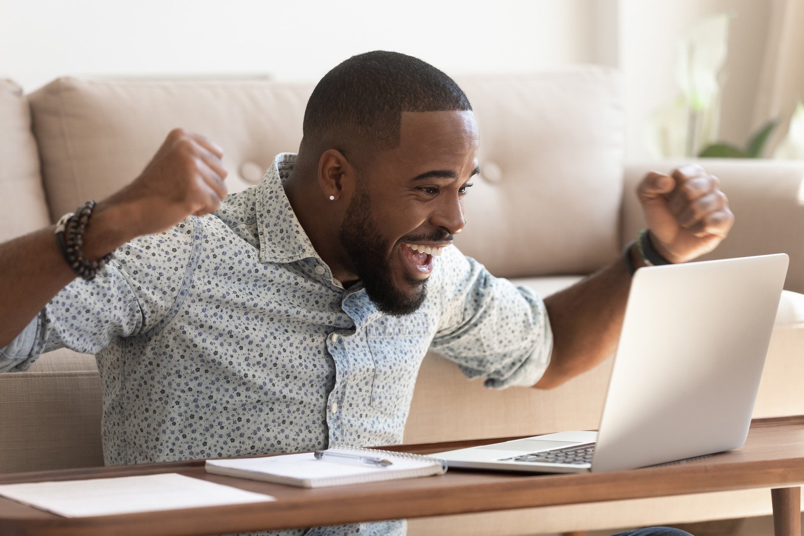 Homem Africano animado ler mensagem no computador comemorando a oportunidade recebida - Fotos do Canva