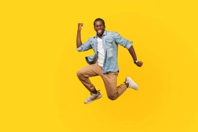 Homem alegre pulando de alegria no ar - Fotos do Canva