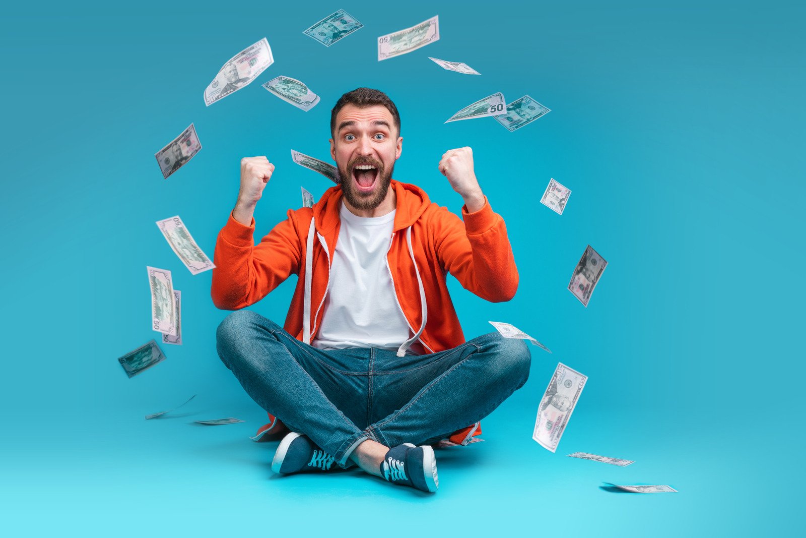Homem de sorte comemorando vitória em dinheiro depois de apostar online no site da casa de apostas - Fotos do Canva