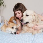 Jovem mulher com cachorro de estimação deitado na cama - Fotos do Canva