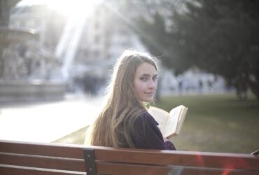 Livro de leitura tranquilo da mulher no parque - Fotos do Canva