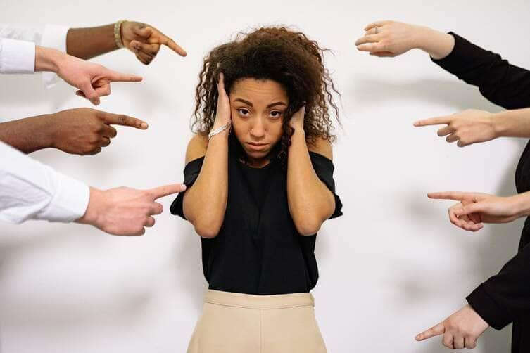 Pessoas apontando o dedo para uma mulher estressada - Fotos do Canva