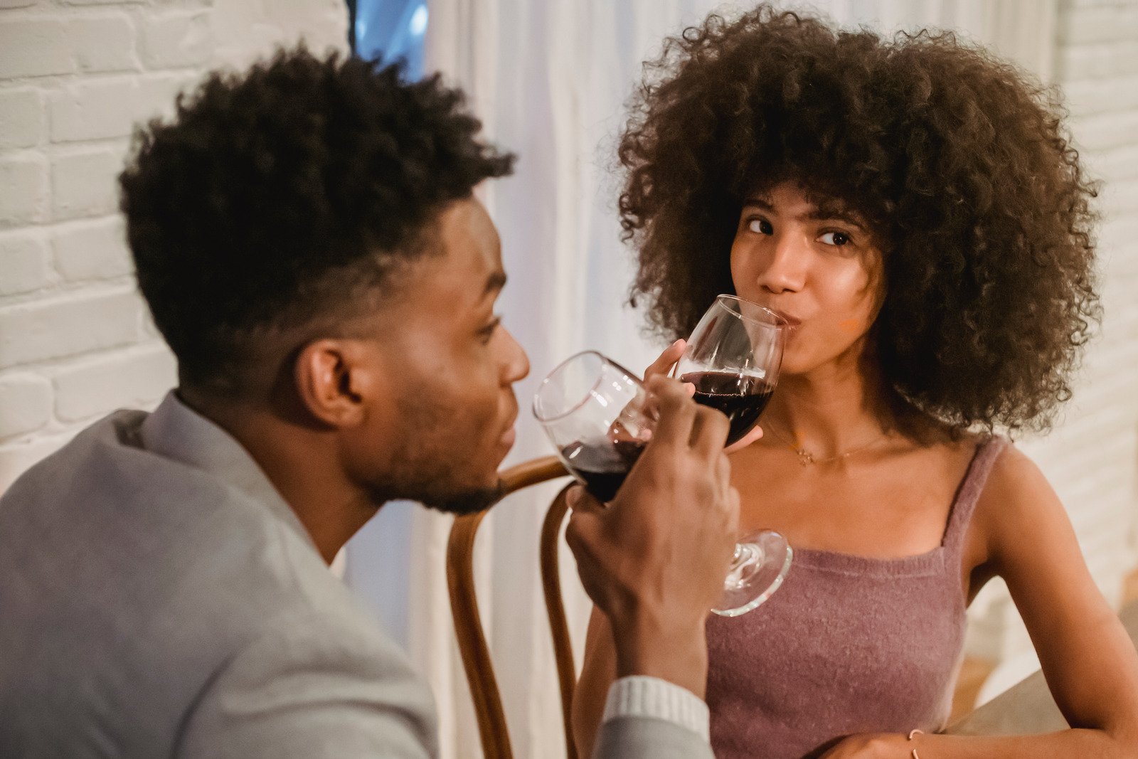 Casal negro bebendo vinho enquanto tem encontro na mesa - Fotos do Canva