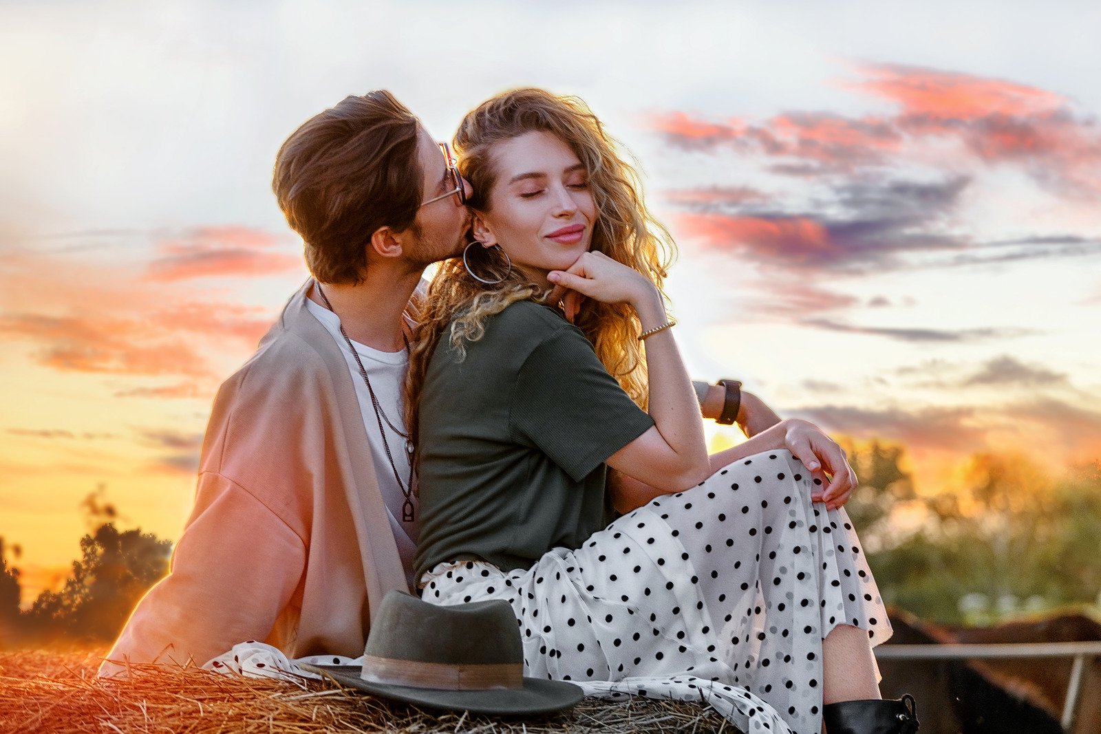 Homem beijando namorada atraente no palheiro ao pôr do sol - Fotos do Canva
