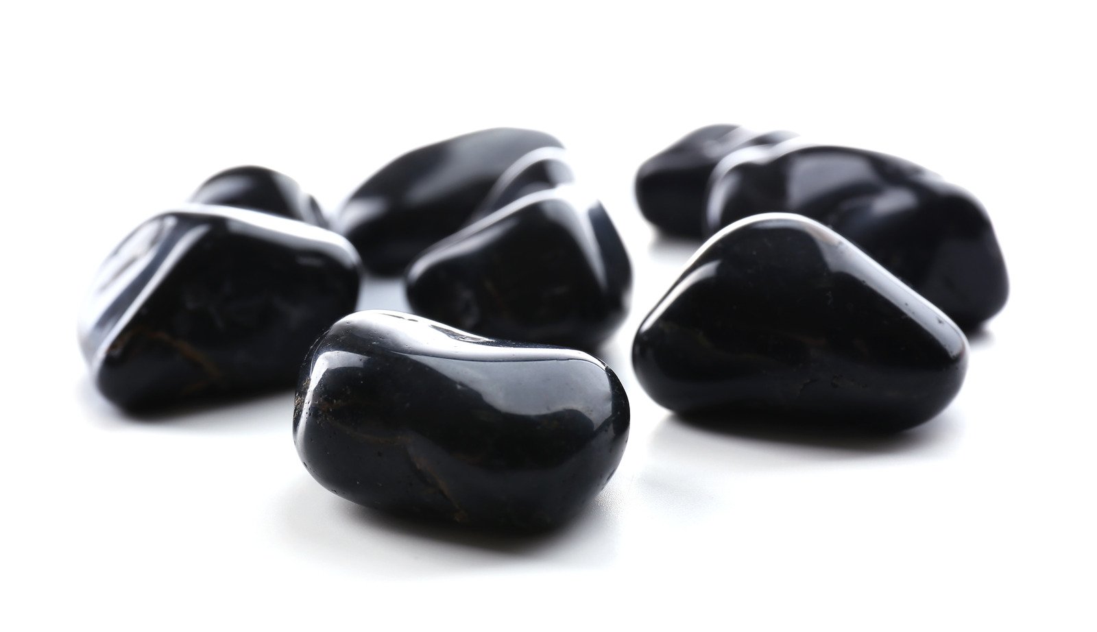 Pedras de ônix pretas em fundo branco - Fotos do Canva