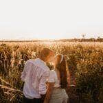 Casal apaixonado beijando no vasto campo ao pôr do sol - Fotos do Canva