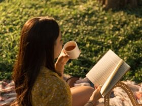 Mulher bebendo chá e lendo um livro, foto de alto ângulo - Fotos do Canva