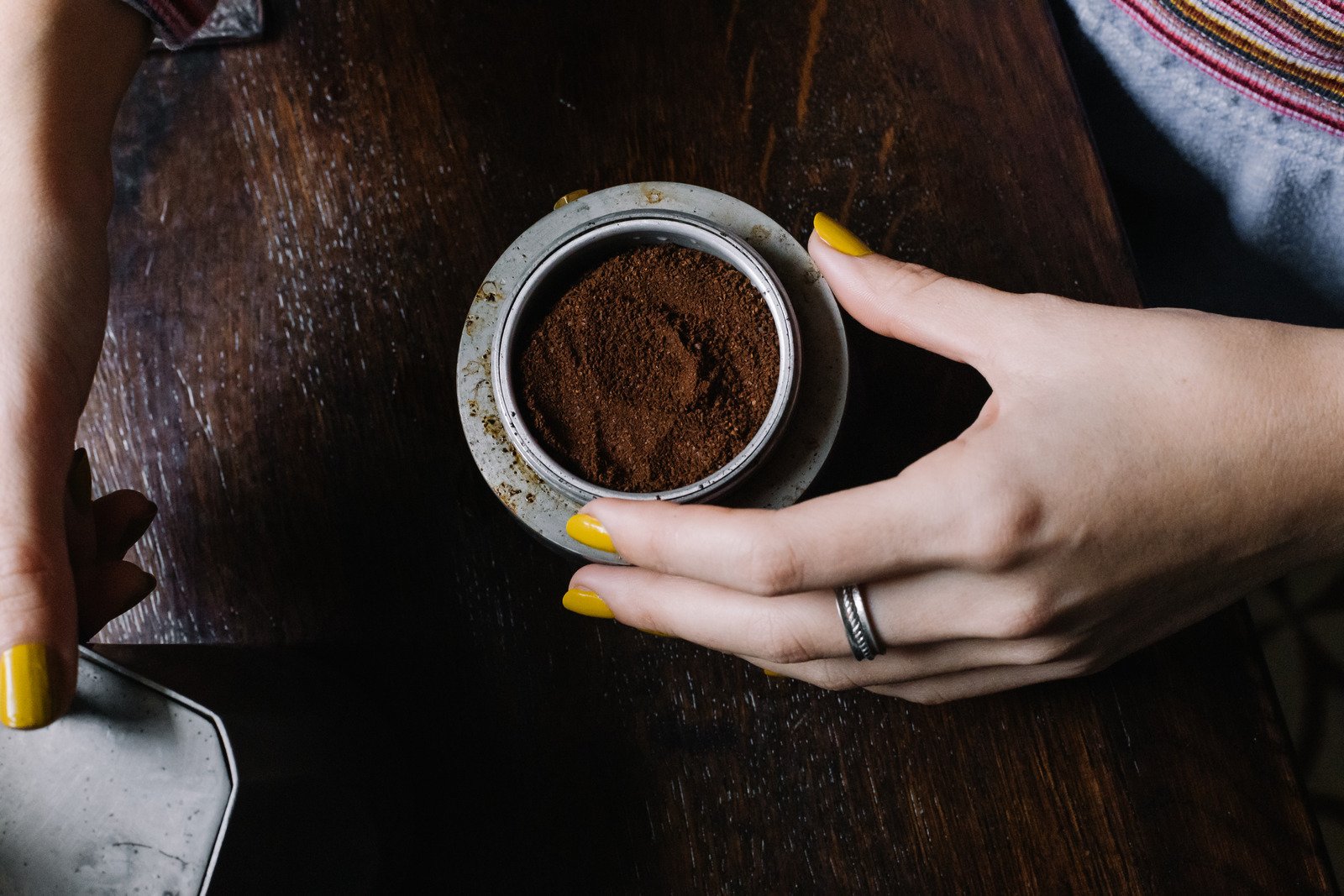 3 Motivos para queimar o Pó do Café 6 Mulher segurando uma tigela de pó de café moído - Fotos do Canva