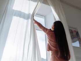Uma mulher abrindo uma cortina branca - Fotos do Canva