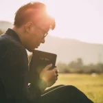 Homem com a Bíblia orando a Deus ao ar livre - Fotos do Canva1