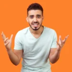 Homem irritado gesticulando em fundo laranja - Fotos do Canva1