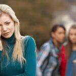 Uma jovem que é discutida por outras mulheres pelas costas