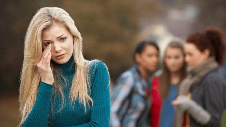 Uma jovem que é discutida por outras mulheres pelas costas