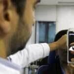 O Dr. Flávio Medina realiza exame de fundo de olho com um retinógrafo portátil,