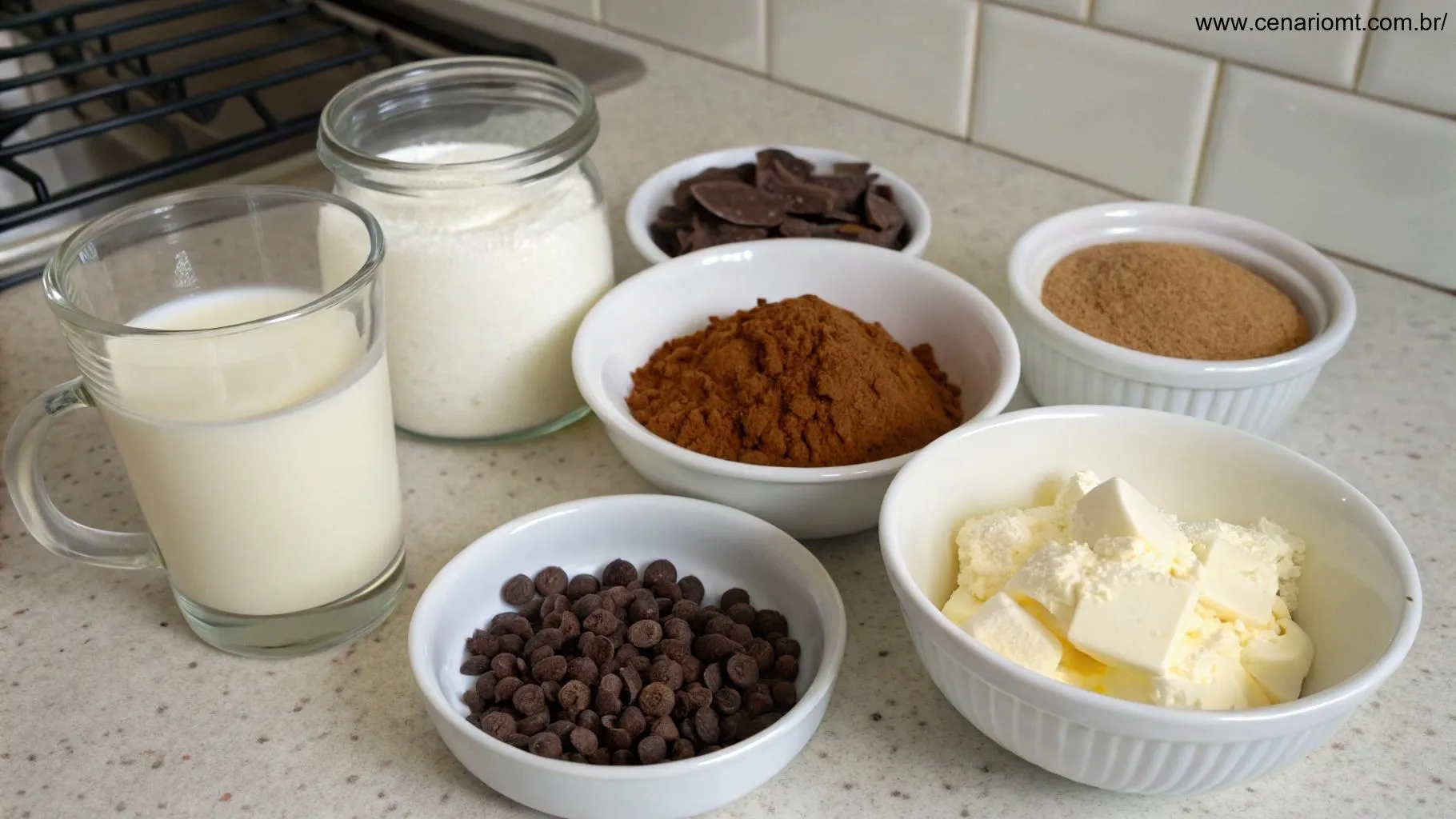 Conjunto de ingredientes para preparar chocolate quente cremoso: leite, cacau em pó, açúcar, gotas de chocolate e baunilha, organizados de forma ordenada sobre uma bancada de cozinha