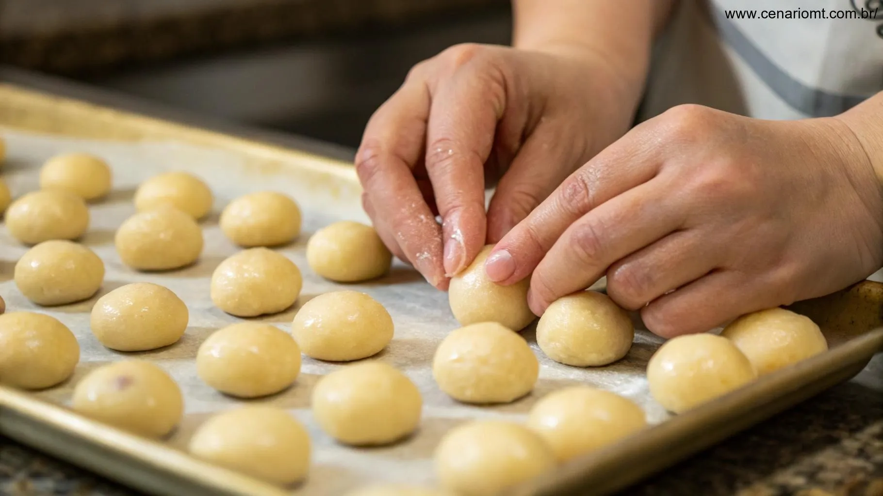 Mãos modelando bolinhas de pão de queijo antes de assar.