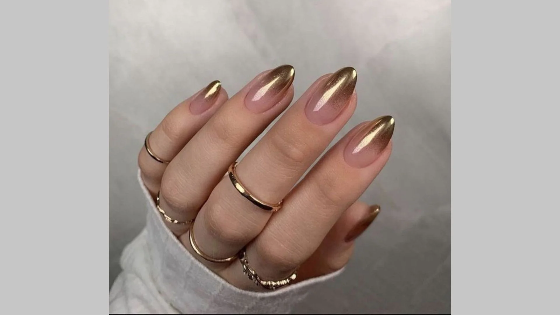 Manicure dourada estilo ombre com transição suave de cor.