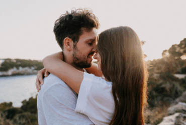 Casal sorridente sob o pôr do sol - Imagem do Canva