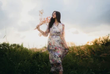 Mulher com flores na mão em um ambiente de natureza