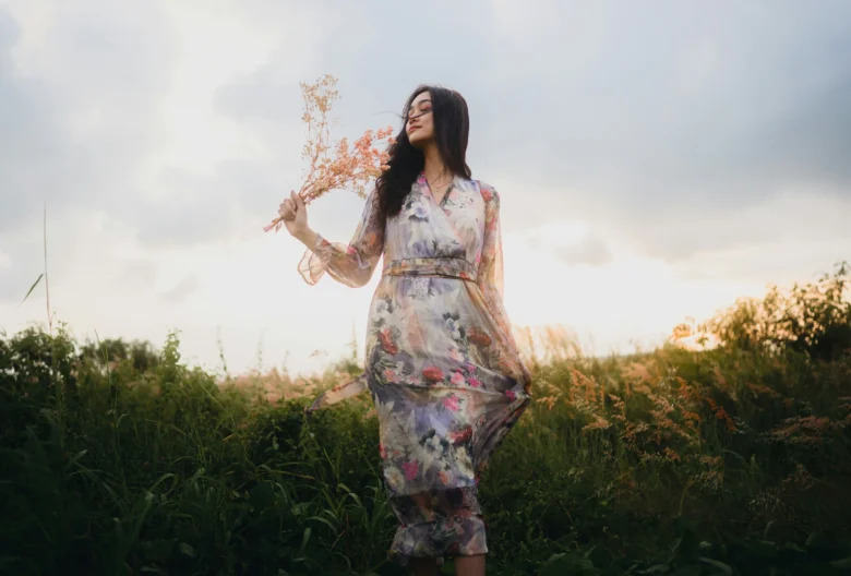 Mulher com flores na mão em um ambiente de natureza
