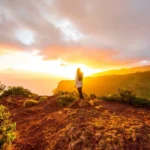 Ilustração de uma montanha ao entardecer com o sol de um lado e a lua do outro, representando o Eixo da Eternidade, por CenárioMT / Canva