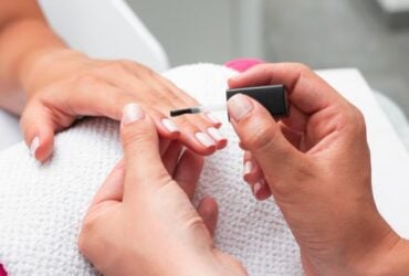 mulher fazendo as unhas de uma cliente 800x445 1