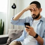 fgv noticias canva 15homem olha celular mao na cabeca