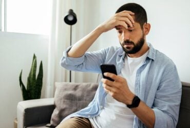 fgv noticias canva 15homem olha celular mao na cabeca