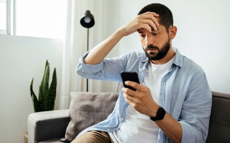 fgv noticias canva 15homem olha celular mao na cabeca